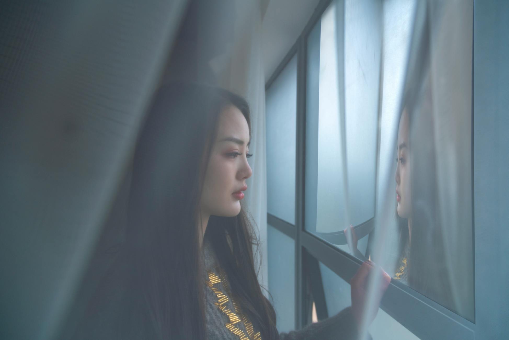 person staring window alone