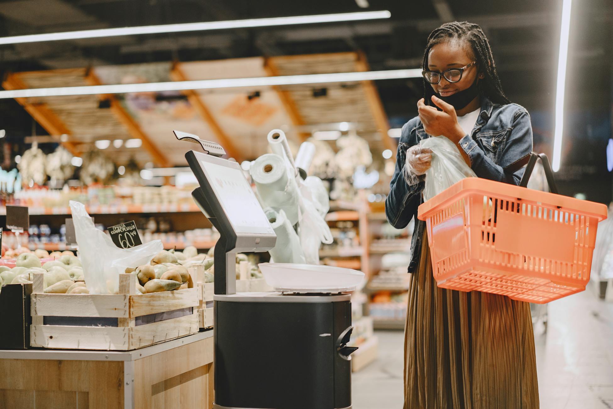 A woman shopping in a supermarket, checking items with a basket in hand.