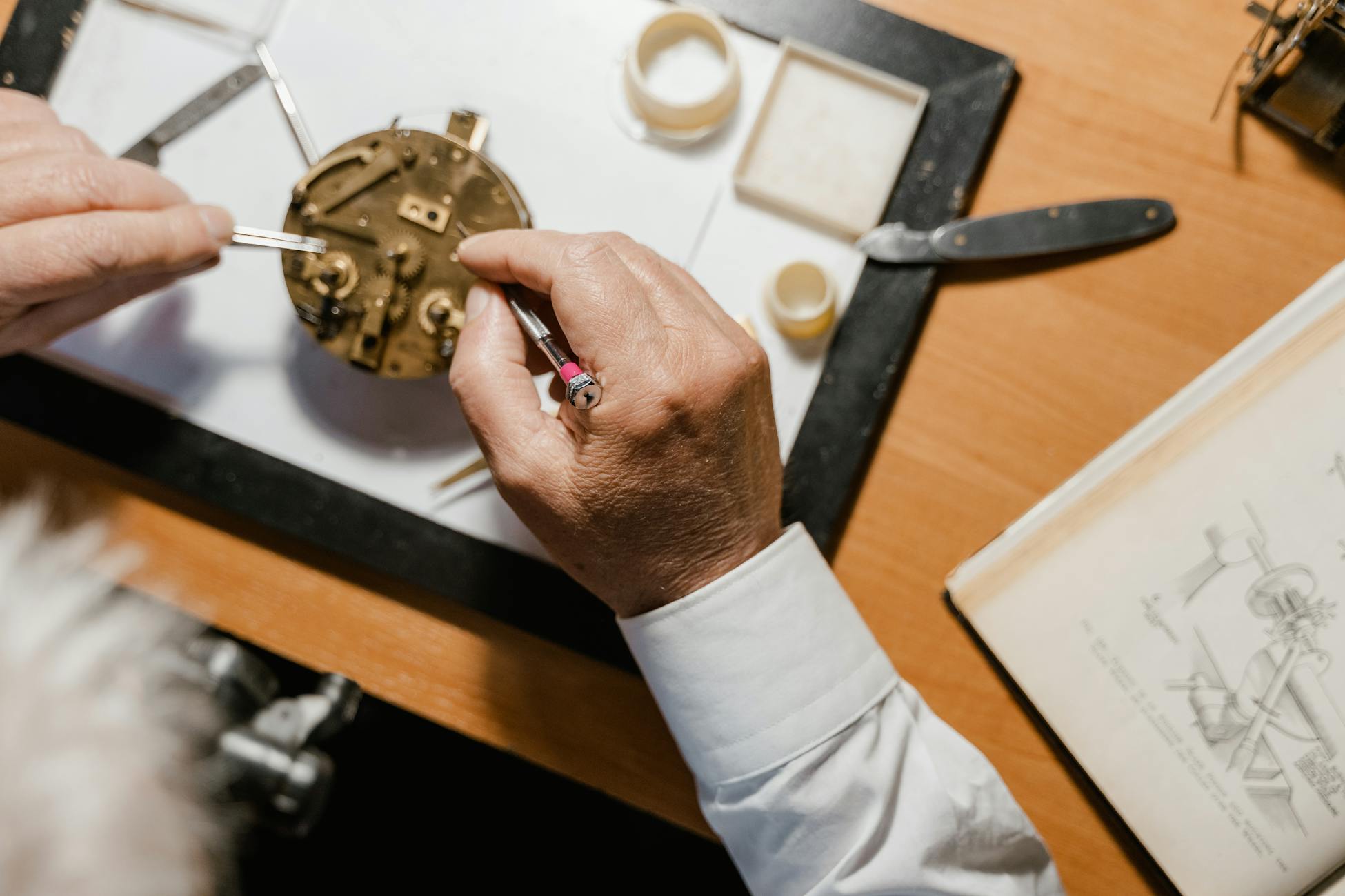 Detailed close-up of a watch repair process with tools and parts on a wooden table.