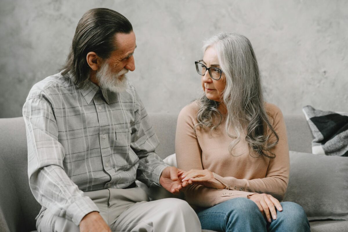 Elderly couple sitting on a sofa, conveying warmth and togetherness.